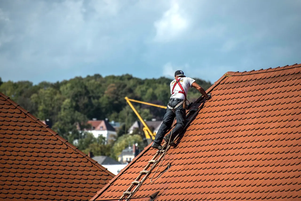 Dachdecker mit Sicherungsgurt auf einem Ziegeldach