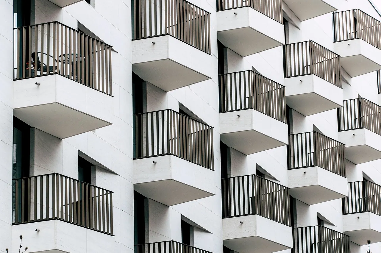 Fassade eines weißen Mietshauses mit Reihen gleicher Balkone